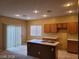 Kitchen with an island, wood cabinets, and tiled flooring at 7667 Borealis St, Las Vegas, NV 89123