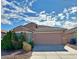 Tan house with a two-car garage and well-maintained landscaping at 6495 Coldwater Bay Dr, Las Vegas, NV 89122