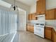 Kitchen features wood cabinets, white appliances and tile flooring at 6495 Coldwater Bay Dr, Las Vegas, NV 89122