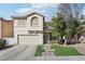 Two-story home with a beige exterior, attached garage, and landscaped yard at 6046 Notre Dame Ave, Las Vegas, NV 89110