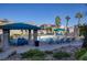 Community pool with lounge chairs, umbrellas, and a shaded seating area at 9975 Peace Way # 1058, Las Vegas, NV 89147