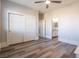 Spacious bedroom with wood-look floors, white doors, and ceiling fan at 453 Punto Vallata Dr, Henderson, NV 89011