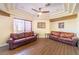 Cozy sitting area with two leather couches, tile flooring and a ceiling fan at 1056 Calico Ridge Dr, Henderson, NV 89011