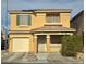 Two story house with tan exterior, green shutters, and a two car garage at 6824 Mesita Ave, Las Vegas, NV 89122