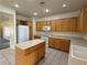 Kitchen with island, wood cabinets, and white appliances at 2136 Desert Woods Dr, Henderson, NV 89012