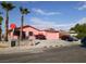 Pink single story home with a two-car garage and landscaped yard at 5212 Rou Cir, Las Vegas, NV 89122