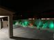 Landscaped backyard at night with green lighting at 6442 Kobe Knoll Ct, Las Vegas, NV 89141