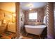 Bathroom with freestanding bathtub, tiled walls, and a twisting column at 4381 Flagship Ct, Las Vegas, NV 89121