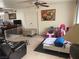 Living room with a brown leather couch, play area, and tile floor at 2813 Searles Ave, Las Vegas, NV 89101