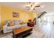 Living room with hardwood floors, gray couch, and yellow accent wall, view of dining area and stairs at 3949 S Torrey Pines Dr, Las Vegas, NV 89103