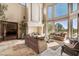 Spacious living room with a large stone fireplace and expansive windows at 22 Augusta Canyon Way, Las Vegas, NV 89141