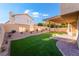 Landscaped backyard with artificial turf, pergola, and patio at 7813 Paper Flower Ct, Las Vegas, NV 89128