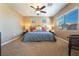 Spacious bedroom with a king-size bed, ceiling fan, and carpeted flooring at 8224 Chimney Bluffs St, North Las Vegas, NV 89085