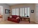 Cozy sitting room featuring a red leather sofa and plantation shutters at 2309 Aztec Ruin Way, Henderson, NV 89044