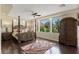 Main bedroom with a four-poster bed and picturesque golf course views at 11534 Glowing Sunset Ln, Las Vegas, NV 89135