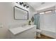 Modern bathroom with white vanity, a large mirror, and a bathtub at 4599 Ordway Dr, Las Vegas, NV 89139