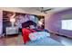 Purple bedroom with floral wall mural, king bed, and hardwood floors at 10052 Baystone St, Las Vegas, NV 89141