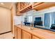 Wet bar with wood cabinetry, wine rack, and view into Gathering room at 10052 Baystone St, Las Vegas, NV 89141