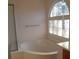 Bathroom with corner bathtub and a window at 7621 Ribbon Rock Ct, Las Vegas, NV 89139