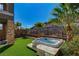 Backyard oasis with a hot tub, artificial turf and palm trees at 49 Strada Moscato, Henderson, NV 89011