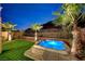 Night time view of backyard hot tub, palm trees and artificial turf at 49 Strada Moscato, Henderson, NV 89011