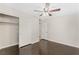 Bright bedroom with dark hardwood floors, ceiling fan, and mirrored closet doors at 1836 Kenneth St, North Las Vegas, NV 89030