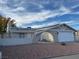 Tan house with white garage door and gated entryway at 617 Hidden Valley Dr, Henderson, NV 89002