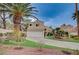 Beautiful two-story home with palm trees, a green lawn, and a two-car garage at 8352 Tide Pool Dr, Las Vegas, NV 89128