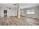 Open-concept living room with wood-look flooring and an arched entryway leading to the front door at 5132 Spencer St, Las Vegas, NV 89119