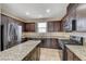 Granite kitchen island, stainless steel appliances, dark cabinets at 4591 Woolcomber St, Las Vegas, NV 89115