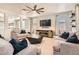 Spacious living room with light-colored sofas, fireplace, and large TV at 7470 Pepperbox Ave, Las Vegas, NV 89179