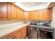 Laundry room with wood cabinets and modern appliances at 14 Pheasant Ridge Dr, Henderson, NV 89014