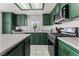 Spacious kitchen with dark green cabinetry and granite countertops at 4712 Wild Oak Way, North Las Vegas, NV 89031