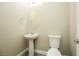 Clean bathroom with pedestal sink, toilet and oval mirror at 9500 Alma Ridge Ave, Las Vegas, NV 89178