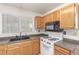 Close-up of the kitchen's stove, sink, and cabinetry with updated countertops at 2751 Desert Stream Ct, Las Vegas, NV 89156