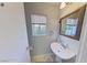 Clean bathroom with pedestal sink, mirror, and window at 3368 Epson St, Las Vegas, NV 89129