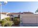 Tan two-story stucco home with tile roof and attached garage at 3356 Racquet St, Las Vegas, NV 89121