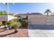 Tan two-story stucco home with tile roof, attached garage, and landscaping at 3356 Racquet St, Las Vegas, NV 89121