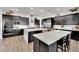 Gourmet kitchen boasts dark cabinetry, large island, and quartz countertops at 2188 Radiant Horizon Ave, Henderson, NV 89052