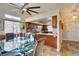 Open floor plan with a kitchen and dining area, featuring wood cabinets and a glass table at 3816 Sunking St, Las Vegas, NV 89130