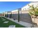 Landscaped backyard with grassy area, block wall, and mature plants at 7208 Grace Estate Ave, Las Vegas, NV 89113