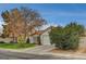 Front view of a single-story house with a spacious lawn and driveway at 571 Macbrey Dr, Las Vegas, NV 89123