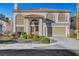 Inviting two-story home with a tiled roof, arched windows, and a well-maintained front yard at 2430 Antler Point Dr, Henderson, NV 89074