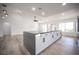 Modern kitchen with white cabinets, large island, and wood-look flooring at 9637 Blue Bell Dr, Las Vegas, NV 89134