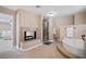 Main bathroom with soaking tub, walk-in shower, and fireplace at 9404 Low Tide Ct, Las Vegas, NV 89117