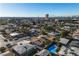 Aerial view of the house, pool, and surrounding neighborhood with distant city views at 4306 Swandale Ave, Las Vegas, NV 89121