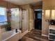 Bathroom with soaking tub, walk-in shower, and wood-look flooring at 6417 Winter Moon St, North Las Vegas, NV 89084