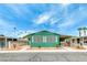 Quaint green manufactured home with covered carport and landscaped yard at 5473 Aldama Rd, Las Vegas, NV 89122