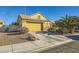 Front view of the house with driveway, landscaping, and a yellow garage door at 5732 Breezy Wind Ct, North Las Vegas, NV 89081