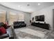 Spacious living room with leather couches, large TV, and gray flooring at 1604 Bontemps Ct, Henderson, NV 89052